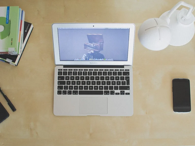 Mesa de trabalho moderna e minimalista com laptop aberto exibindo slides de apresentação profissional criados com IA